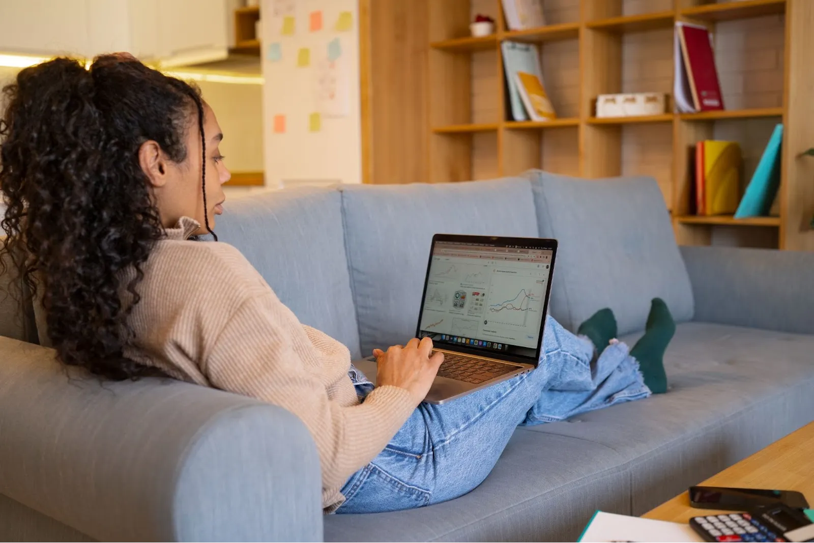 Young woman using a laptop at home, browsing the internet, representing Spectrum plans and pricing in Tampa and what customers actually get.
