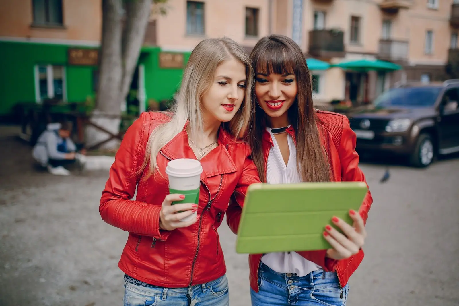 Two girls smiling and enjoying using a tablet together, with overlaid text ‘Comparing Windstream Internet Prices in Lexington, Kentucky.