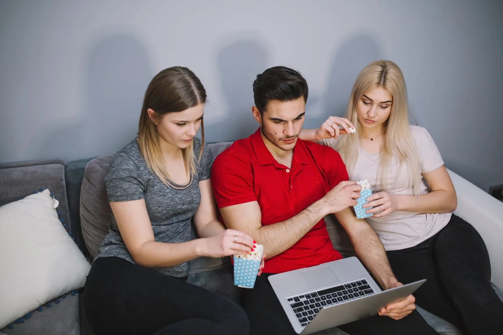 A man using a laptop, seated between two women, all focused on the screen—illustrating the concept of shared digital experiences. Caption reads: “Why Bundling Makes Sense Today.”
