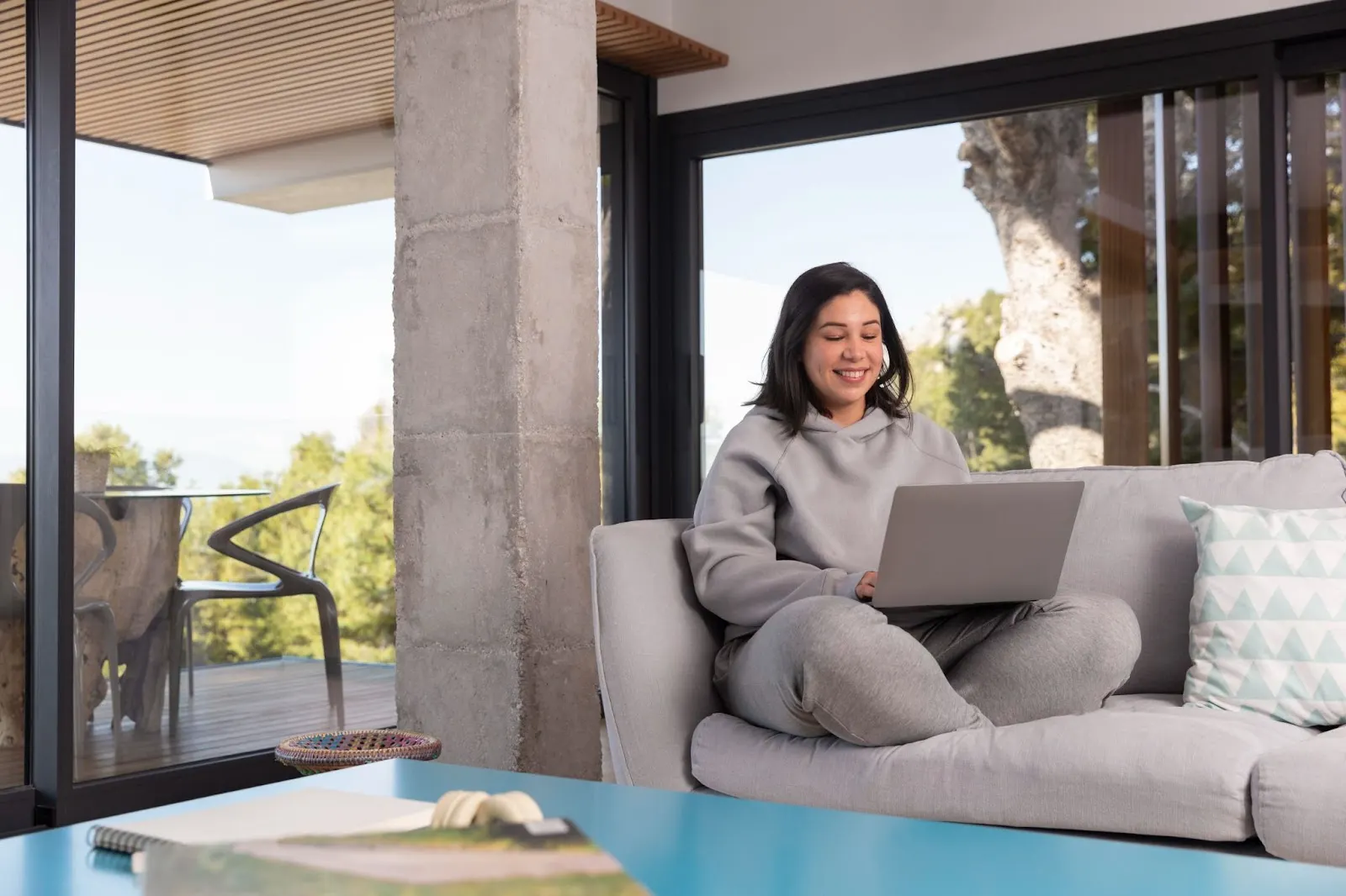 Young woman using a laptop on a sofa, representing modern internet use. Related to blog post about Windstream Internet in Oklahoma.