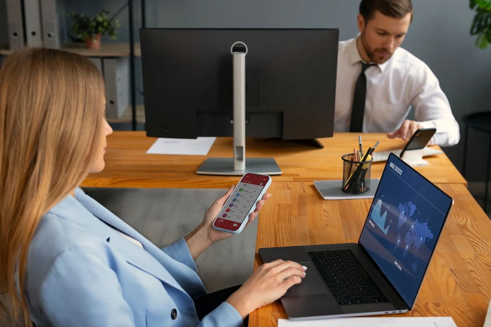 Young woman using laptop and smartphone to stay connected online, representing Spectrum Internet cost and its importance in daily operations.